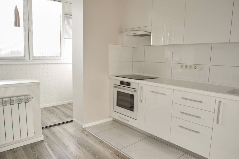 Luxury modern kitchen in new apartment. New white kitchen with appliances and beautiful interior. Elegance of style.